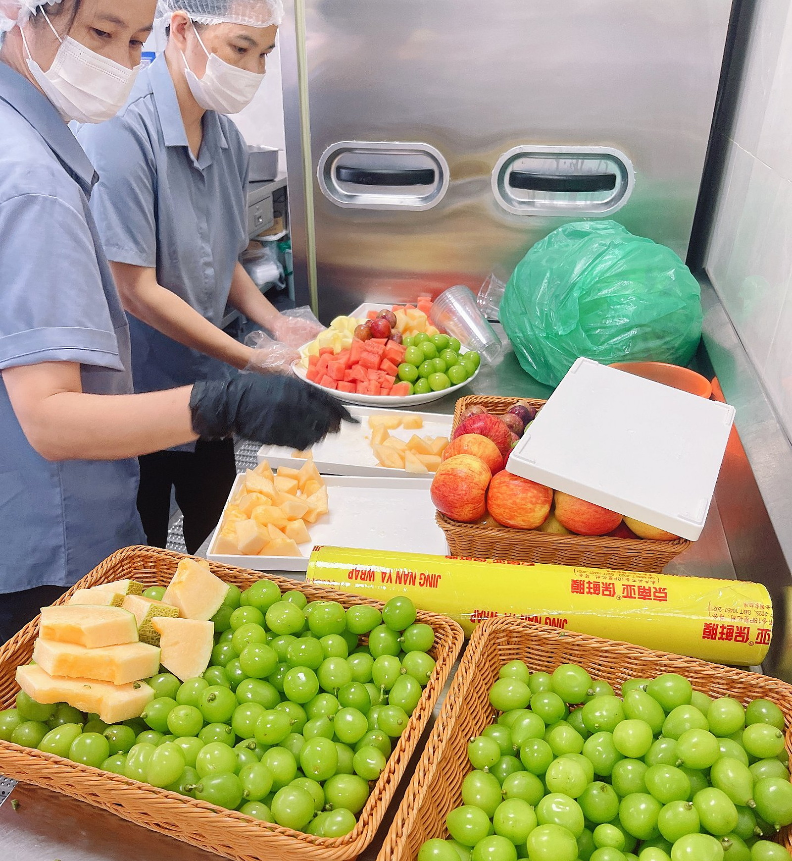 供餐后厨现场:青提、哈密瓜、西瓜、菠萝现切装盘分装